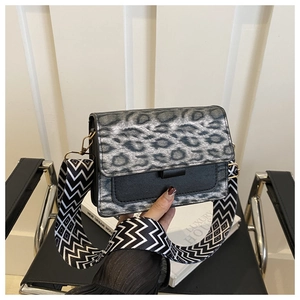 Close-up of leopard print crossbody bag with wide geometric woven shoulder strap