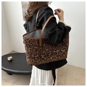 Detailed view of leopard print tote bag with brown leather straps and spacious interior
