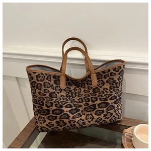Detailed interior view of a leopard print tote bag with brown handles and blue lining