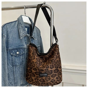 Détail du sac cabas léopard avec étiquette tissée noire et boucle métallique