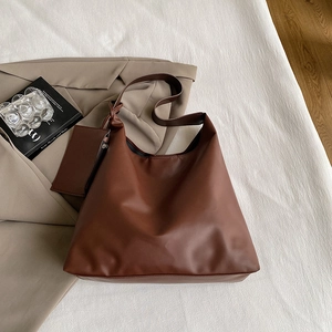 Detailed view of deep brown matte leather tote bag with matching small zipper pouch