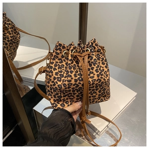 Detail of leopard print bucket bag with brown drawstring closure and golden metal eyelets