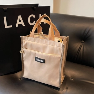 Fashionable beige oxford cloth tote bag with brown canvas handles and front zipper pocket