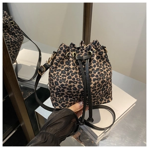 Macro detail of leopard print bucket bag with black drawstring closure and gold hardware