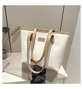 Detailed shot of cream and camel tote bag showing PU leather texture and Fashion label