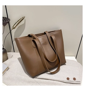 Detail of fashion embossed label on brown leather tote bag with premium stitching