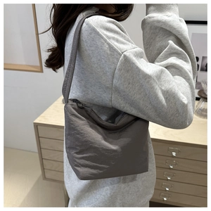 Détail du sac seau en nylon gris foncé avec texture plissée et large bandoulière