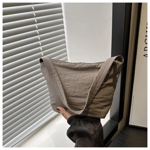 Detail of taupe wrinkled nylon shoulder bag with a wide strap and zip closure