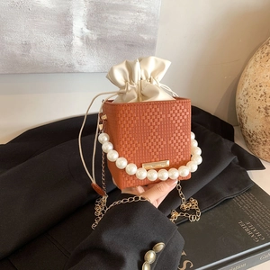 Orange woven mini bucket bag with pearl handle and golden chain strap for women