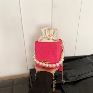 Mini rose pink woven bucket bag with large pearl handle and gold chain shoulder strap