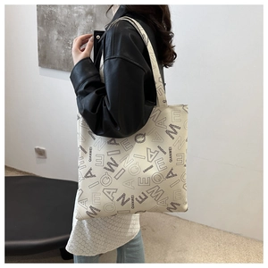 Side view of white canvas tote bag with QIANWEI letter print worn by a fashion model