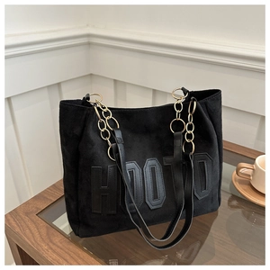 Dettaglio borsa tote in pelle scamosciata nera con ricamo HOOTD e catena in metallo