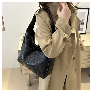 Detailed view of black woven leather texture and craftsmanship on a Hobo tote bag
