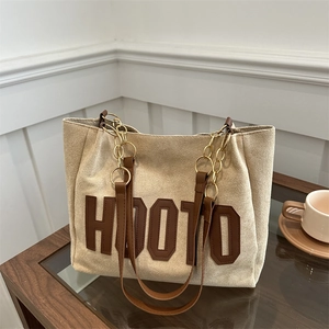 Borsa tote minimalista in pelle scamosciata beige con scritta HOOTO e tracolla marrone