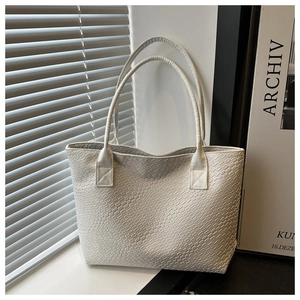 Detail of white tote bag featuring premium woven texture and minimalist leather design