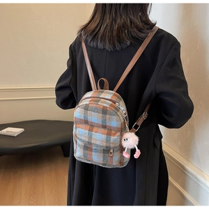 Plaid wool mini backpack detail with leather straps and a plush charm on model back