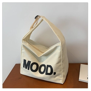 Detail of off-white canvas tote bag featuring MOOD print and adjustable shoulder strap