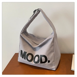 Detail view of light grey canvas bag featuring MOOD. print and wide shoulder strap