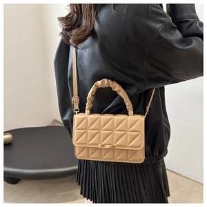 Detail of khaki crossbody bag featuring quilted stitching and cloud handle