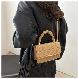 Detail of camel quilted crossbody bag with cloud handle and elegant gold metal clasp
