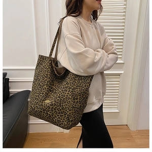 Close-up of leopard print canvas tote bag featuring a high-quality gold metal logo detail