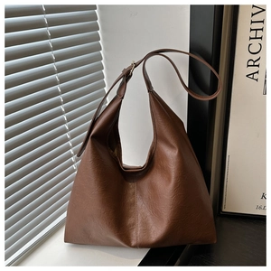 Detail of vintage brown Hobo bag featuring a crescent shape and adjustable leather strap