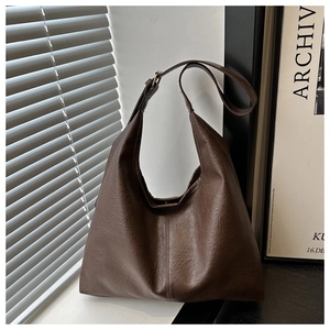 Detailed view of dark brown pebbled leather texture on a vintage hobo shoulder bag