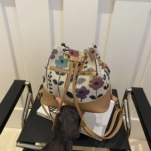 Ethnic style bucket bag featuring floral jacquard canvas and camel leather patchwork