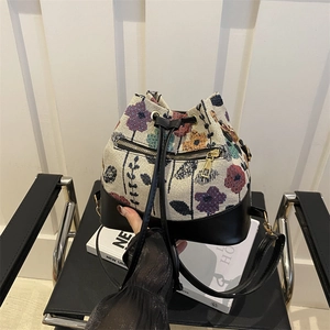 Ethnic embroidered bucket bag with leather trim and floral jacquard pattern
