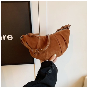Détail du sac croissant marron plissé avec texture en daim et fronces verticales chic