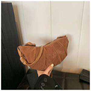 Vue détaillée du sac croissant en daim marron avec texture plissée et poignée nouée