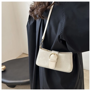 Dettaglio borsa baguette beige con elegante fibbia dorata su pelle opaca di lusso