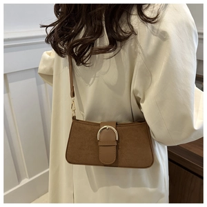 Dettaglio della borsa baguette vintage in pelle scamosciata marrone con fibbia dorata