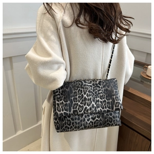 Nahaufnahme der Leopardenmuster-Schultertasche mit goldener Kette am Modell