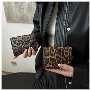 Vista ravvicinata del portacarte leopardato tri-fold con elegante chiusura a busta