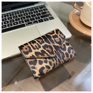Dettaglio porta carte con stampa leopardata e chiusura a busta su una scrivania moderna