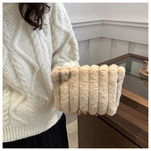 Texture détaillée du sac à main rayé en peluche beige avec fausse fourrure et motifs verticaux