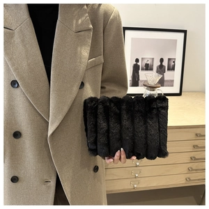 Détail d'un sac à main en fausse fourrure noire à rayures dans un décor hivernal cosy