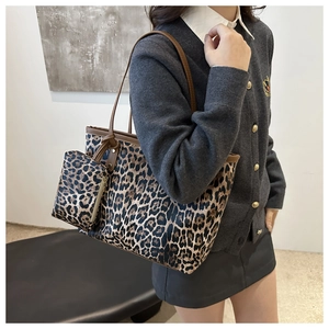 Close-up of leopard print tote bag with brown straps and matching small pouch
