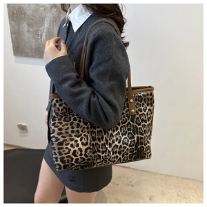 Detail of leopard print tote bag and matching pouch showing the side profile on a model