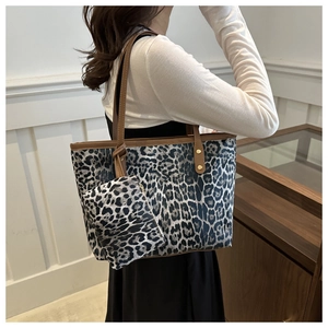 Detailed shot of leopard print tote bag with matching small pouch and gold studs