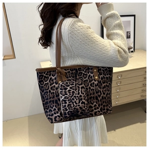Close-up of leopard print tote bag with matching zippered pouch and leather straps