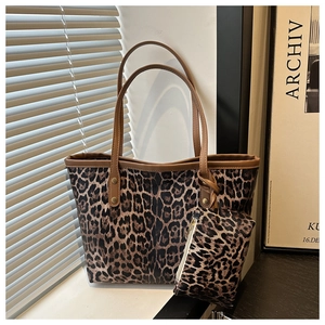Detail of leopard print tote bag set featuring gold rivets and matching small pouch