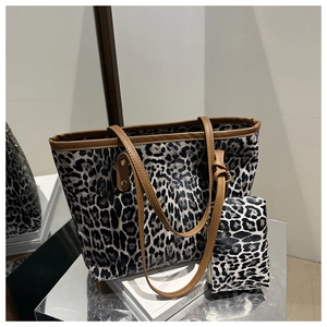 Detail view of leopard print tote bag with matching coin purse on a mirror surface