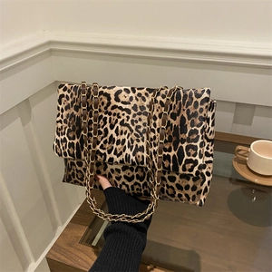 Modische Umhängetasche mit Leopardenmuster und Goldkette auf einem Holztisch-Set