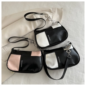 Detailed view of color-block underarm bags in black, pink, and silver with metal floral rings