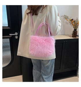 Detail van roze pluche crossbodytas met zachte imitatiebonttextuur en leren handvat