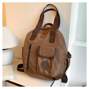Caramel water-resistant nylon backpack with buckle front pocket and storage side pockets