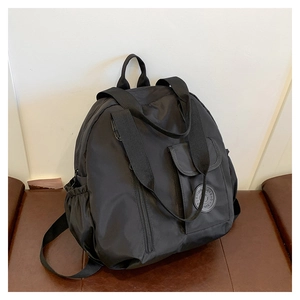 Detail of black nylon backpack featuring adjustable straps and functional side pockets