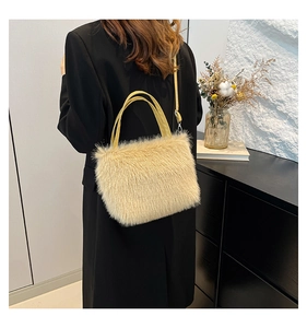 Detailweergave van een beige pluche tas gecombineerd met een zwarte blazer voor de herfst